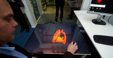 Jonny Gustafsson, forskare på KTH, vrider och vänder på modellen på det holografiska 3D-bord han själv har utvecklat. Foto: Fredrik Sandberg/Scanpix.
